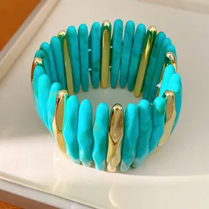 Close-up detail of a turquoise marbled acrylic and gold-tone segment stretch bracelet