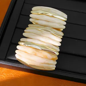 Detailed view of marbled acrylic segments with gold-toned spacers on elastic bracelet