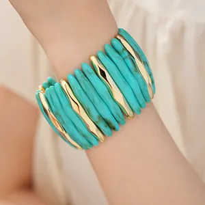 Detailed macro view of marbled teal acrylic and wavy gold stretch bracelet on a wrist