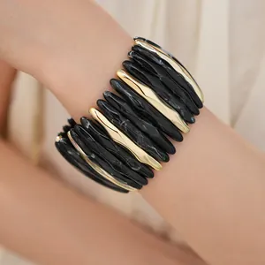 Detail shot of marbled black and gold acrylic beads on an elastic stretch bracelet