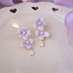 Prachtig detail van paarse bloem oorbellen met zirkoon waterdruppel en witte parels