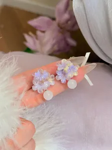Detail paarse bloem oorbellen met zilveren naalden en witte kralen