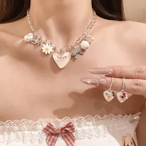 Vue rapprochée d'un ensemble collier et boucles d'oreilles cœur et marguerite