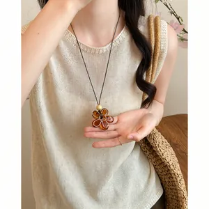 Detailed view of amber flower pendant necklace with resin texture on a female model