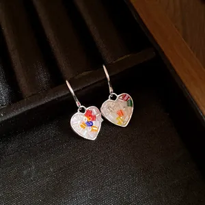 Vue détaillée des boucles d'oreilles cœur en argent avec mosaïque colorée