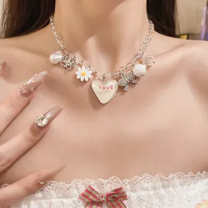 Détail d'un collier de perles de style coréen avec des breloques marguerite et cœur sur un mannequin