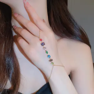 Détail d'un bracelet bague doré avec des zircons cubiques colorés