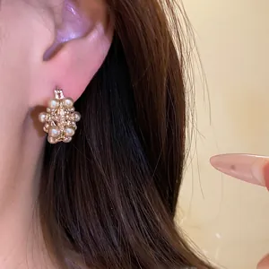 Vintage French hollow pearl flower basket hoop earrings shown on model for elegant style