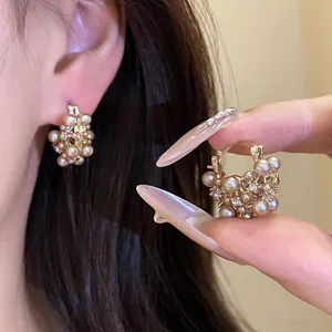 Close-up detail of French vintage hollow flower basket earrings adorned with pearls