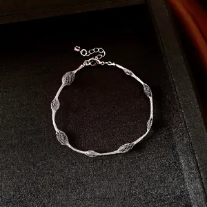 Elegant silver mesh lattice design bracelet presented on a black luxury jewelry display tray