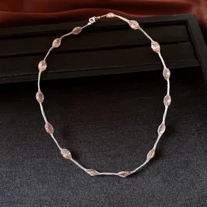 Detail shot of a minimalist silver mesh-wrapped amber bead necklace with elegant luster.