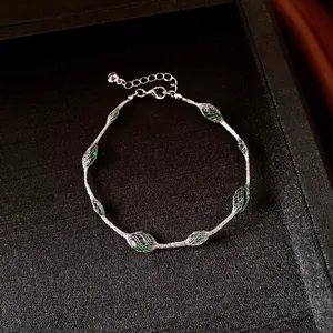 Detail view of a silver-toned mesh bracelet with elegant green candy-colored beads inside.