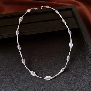 Close-up of minimalist silver chain necklace with delicate mesh bead accents