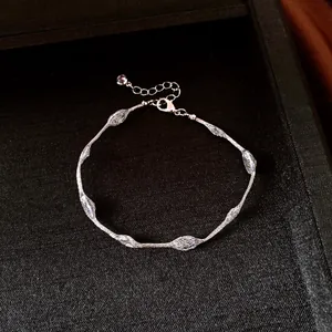 Close-up of silver-tone bracelet with textured oval net beads on black display tray.