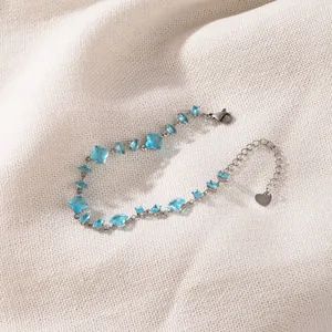 Detailed macro view of a stainless steel aquamarine zircon bracelet on linen background