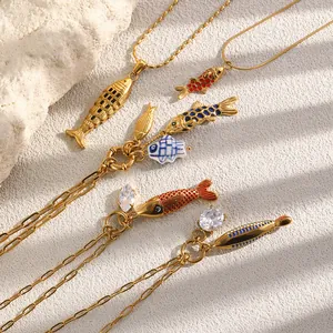 Detalle de colgantes de peces bañados en oro de 18K con esmalte de colores y circonitas.