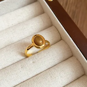 Minimalistischer vergoldeter Ovalring mit Glitzerstein in einer eleganten Schmuckbox