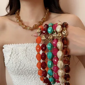 Detailed close-up of colorful acrylic twisted oval bead necklaces with gold spacers
