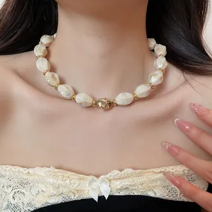 Chic cream marble acrylic chunky necklace with gold accents worn on the neck