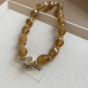 Detailed view of amber twisted acrylic beads on an adjustable gold-tone choker.