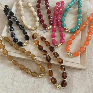 Detail view of multi-color twisted acrylic bead necklaces with gold accent pendants