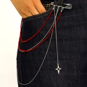 Detalle de accesorio imperdible de moda con cuentas rojas y colgante de estrella en denim