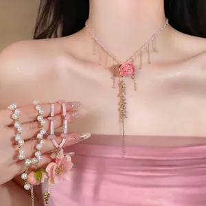Detailed macro view of elegant pink flower pendant necklace and matching pearl bracelets