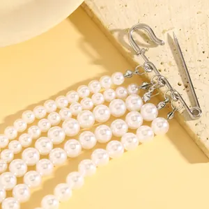 Detalle de elegante broche de borla de perlas con múltiples hilos y alfiler de plata.