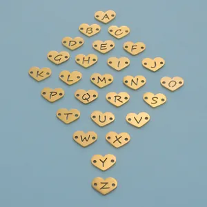 Detail of gold-plated stainless steel heart pendants with A-Z alphabet cutouts.