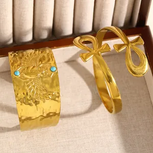 Gros plan de bracelets en acier inoxydable doré ornés de symboles Scarabée et Ankh égyptien