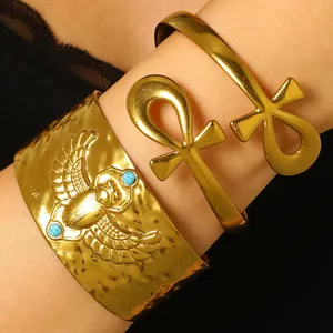 Vue détaillée de bracelets manchettes dorés en acier avec scarabée et croix d'Ankh