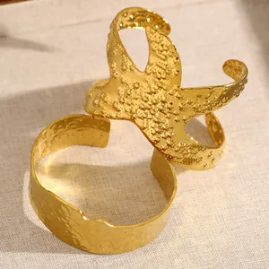 Gros plan détaillé de bracelets manchettes dorés en acier inoxydable à texture martelée fine