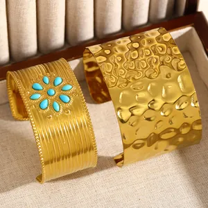 Détail d'un bracelet martelé doré et d'un bracelet large orné de turquoise en boîte.