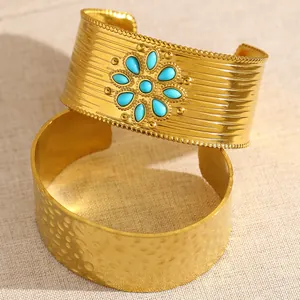 Gros plan détaillé sur un bracelet manchette doré avec des pierres turquoises et martelées