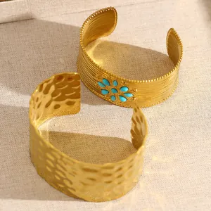 Gros plan de bracelets manchettes dorés avec turquoise et textures martelées.