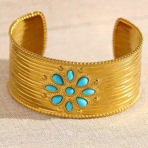 Vue détaillée du large bracelet en acier inoxydable avec motif soleil en turquoise bleue