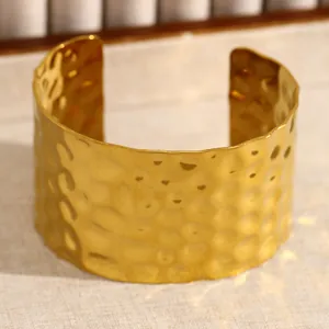 Vue détaillée de la texture martelée et des bords ondulés du bracelet jonc en acier doré