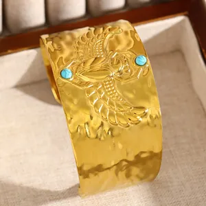 Détail rapproché d'un bracelet manchette doré martelé avec scarabée et pierres turquoises