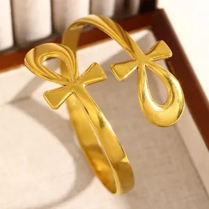 Détail d'un bracelet manchette en acier doré orné de deux symboles Ankh égyptiens.