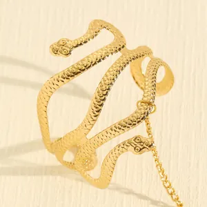 Detailopname van een gouden dubbelkoppige slangenarmband met een fijne schubtextuur.