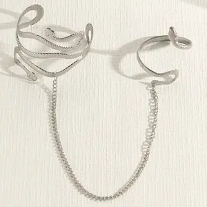 Gedetailleerd overzicht van de zilveren slangarmmanchet en armband verbonden door een ketting.