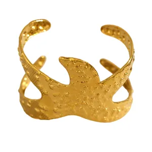 Vue détaillée d'un large bracelet manchette ouvert en acier inoxydable doré martelé