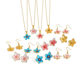 Vista dettagliata del set di gioielli smaltati a fiori con orecchini in oro 18 carati.