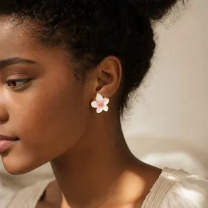 Detailed close-up showing a sweet oil-drop white flower stud earring worn on model's ear