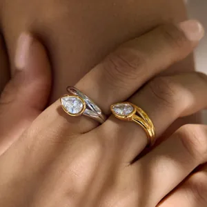 Detail shot of elegant gold and silver teardrop zircon rings with unique ribbed bezel.