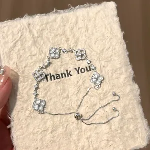 Macro view of adjustable silver bracelet with sparkling cubic zirconia clover flowers