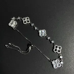 Detailed shot of an adjustable silver bracelet featuring zircon stones and pearl clover charms.