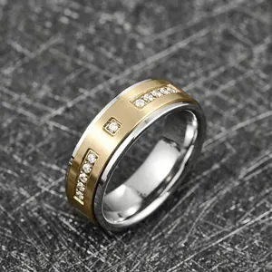 Vue détaillée d'une bague en acier inoxydable bicolore avec finition or brossé et zircons