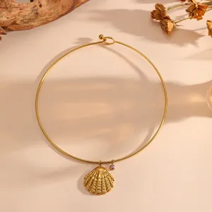 Vue détaillée d'un collier ras du cou doré avec pendentif coquillage et pierre mauve