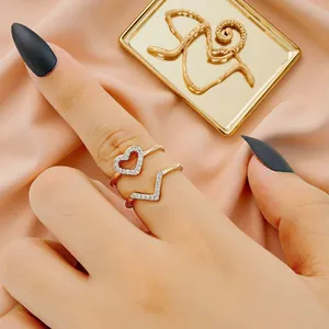Elegant close-up detail van een goudkleurige open ring met hart en V-vorm en strass-steentjes